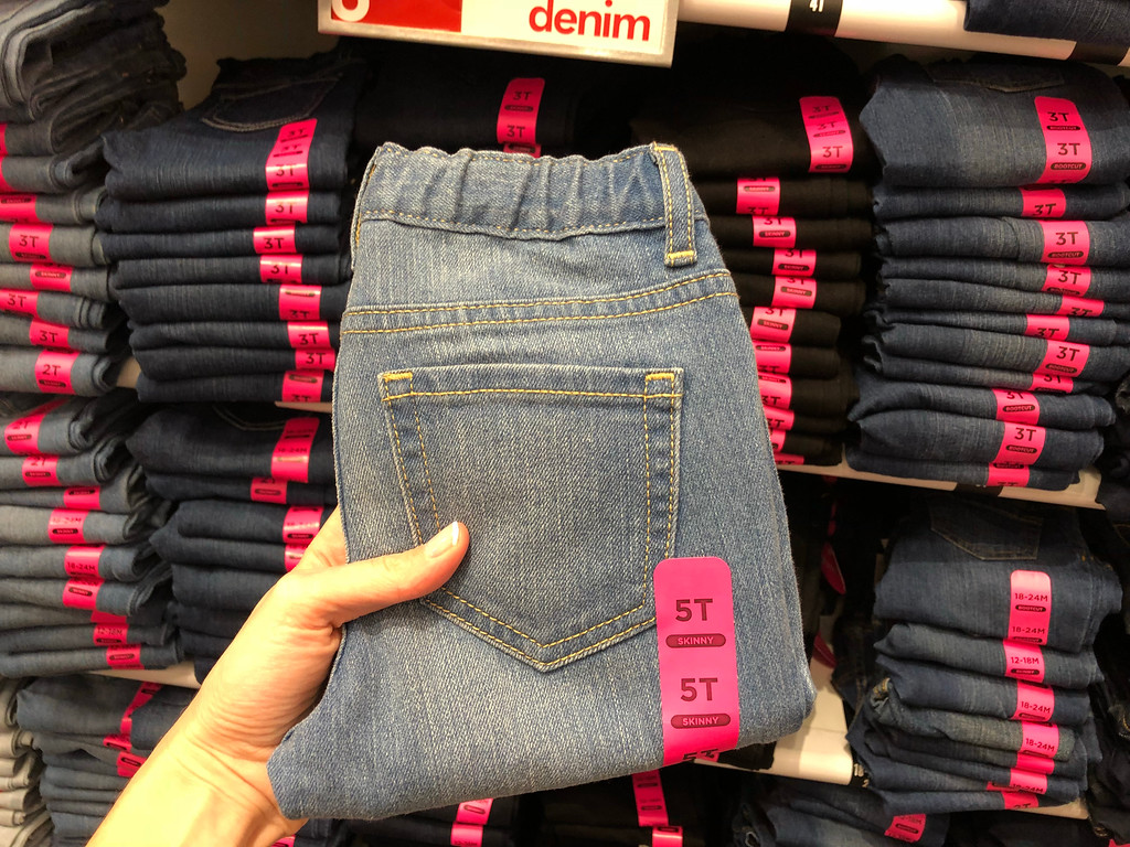 Hand holding up a kid's pair of jeans with flex waist