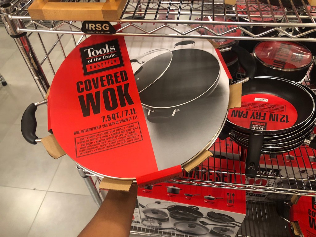 hand holding tools of the trade covered wok in store