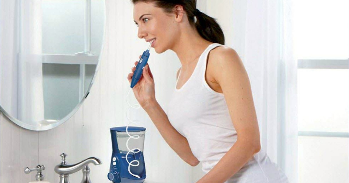 woman using blue waterpik in bathroom