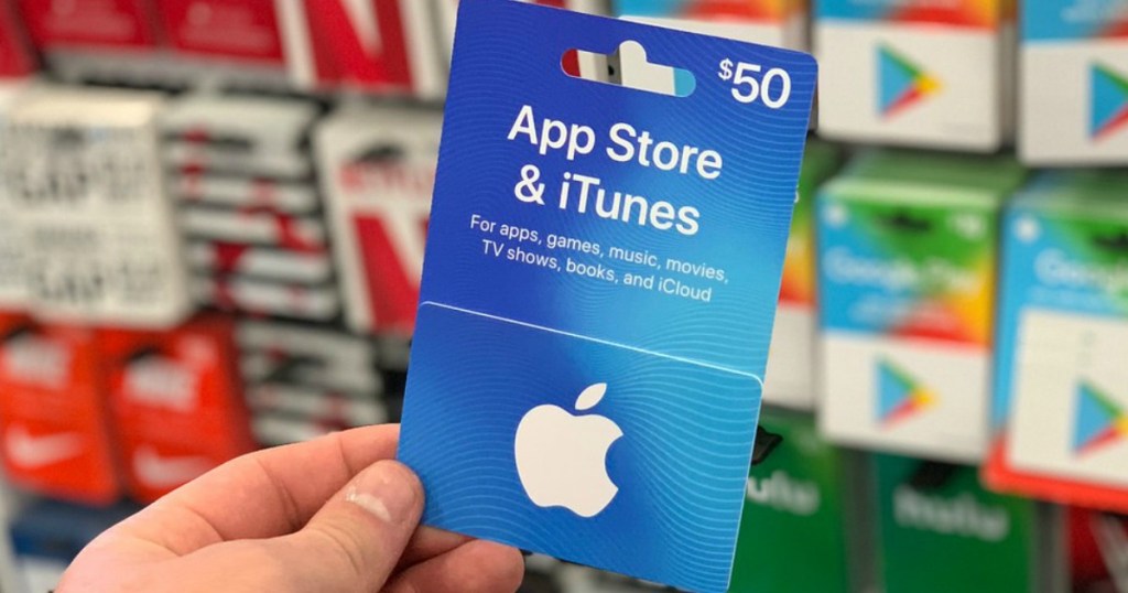 hand holding apple app store and itunes $50 gift card
