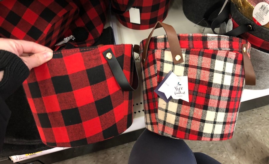 hand holding two red and black baskets in store aisle