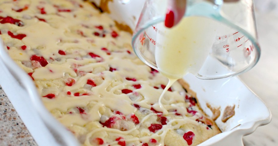 pouring orange glaze on cranberry christmas cake