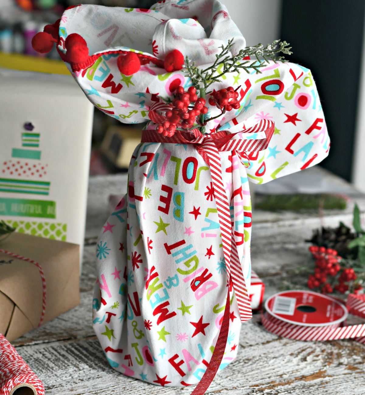 holiday dish towel used to wrap wine bottle as an easy Christmas gift wrapping idea