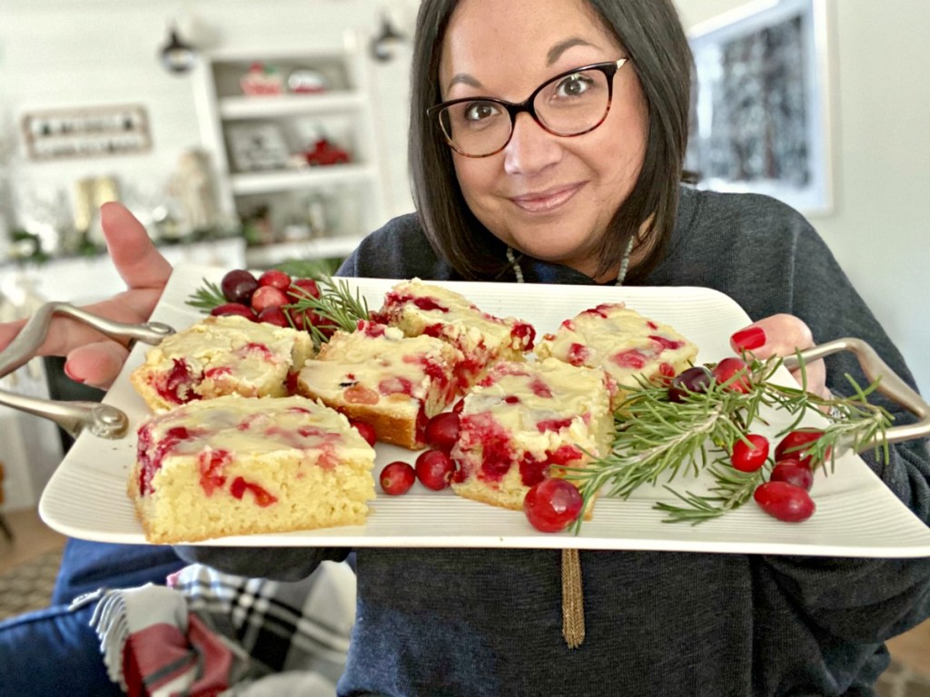 woman holding tray of christmas cranberry cake bars