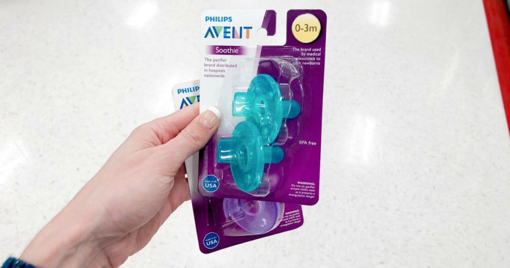 hand holding up 2 packs of avent pacifiers