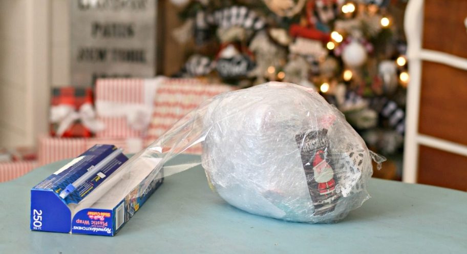 Saran wrap game holiday party game &ndash; partially wrapped ball on a table near the Christmas tree