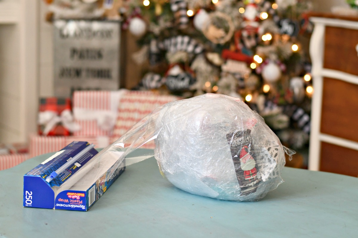 Saran wrap game holiday party game – partially wrapped ball on a table near the Christmas tree