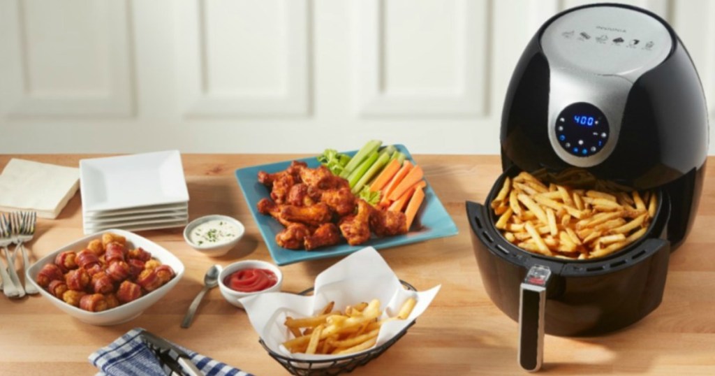 Insignia Digital Air Fryer on counter next to an assortment of air-fried foods