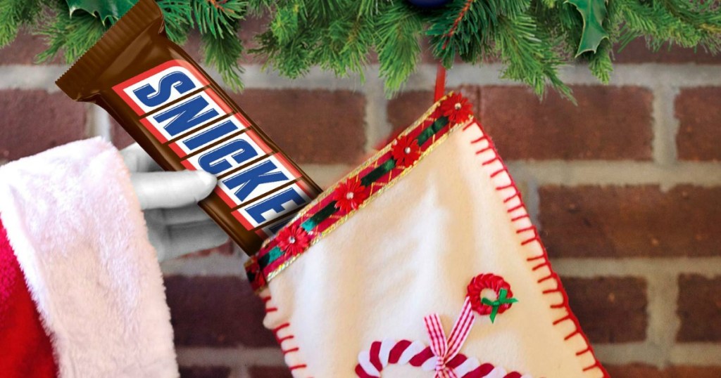 Santa putting Snickers 1 pound bar into a stocking