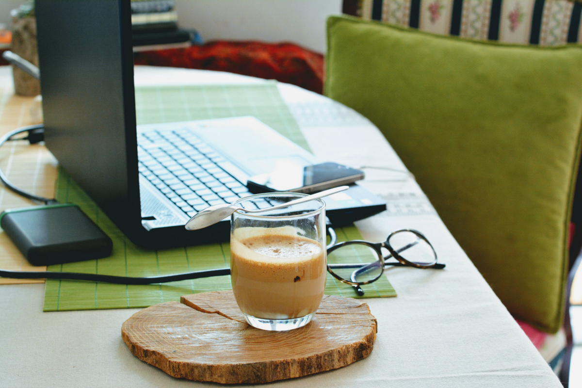 a cup of coffee next to an open laptop