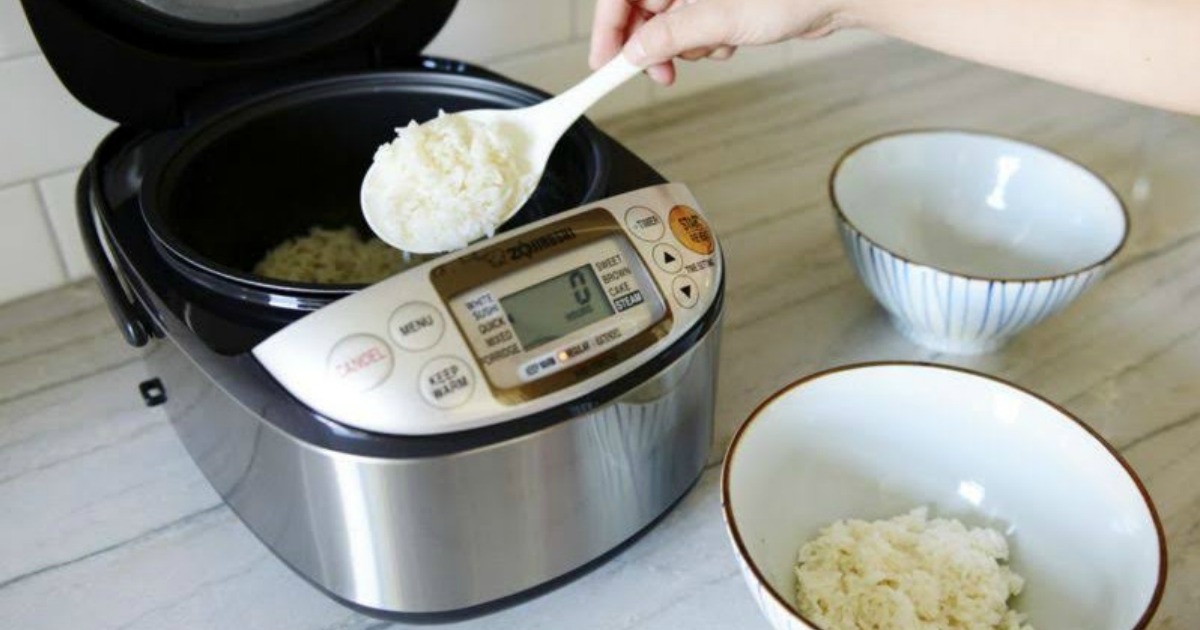 person spooning rice out of a Zojirushi Cooker