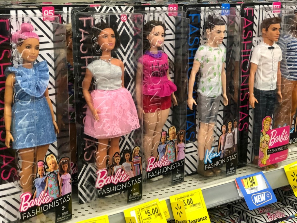 barbie and ken dolls on a shelf in a store