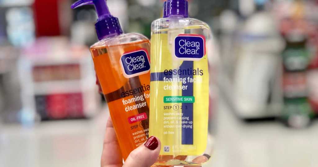 womans hand holding two bottles of clean and clear face washes