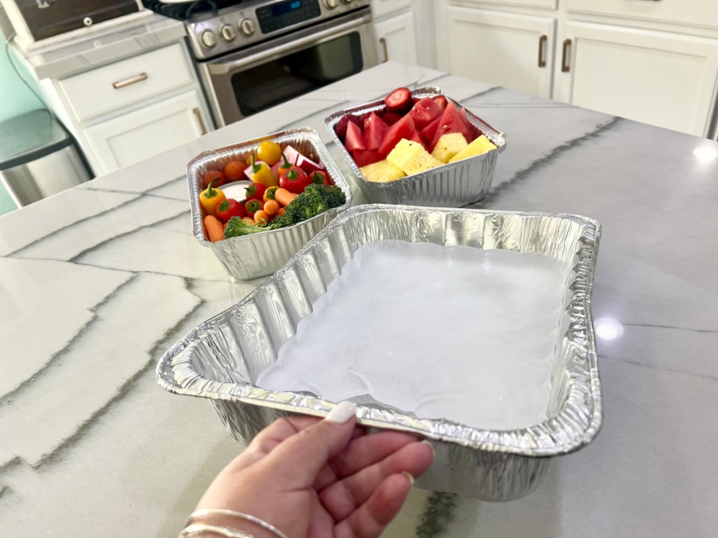 woman using one of her kitchen hacks and placing ice in food tray which will cool the food placed on top of it