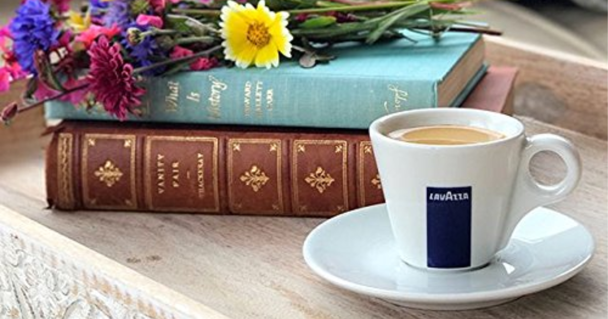 Lavazza Nespresso Compatible Coffee in cup next to book and flowers
