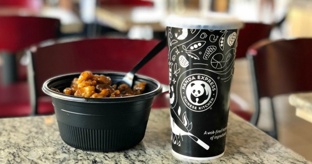 panda express orange chicken entree with soft drink on table