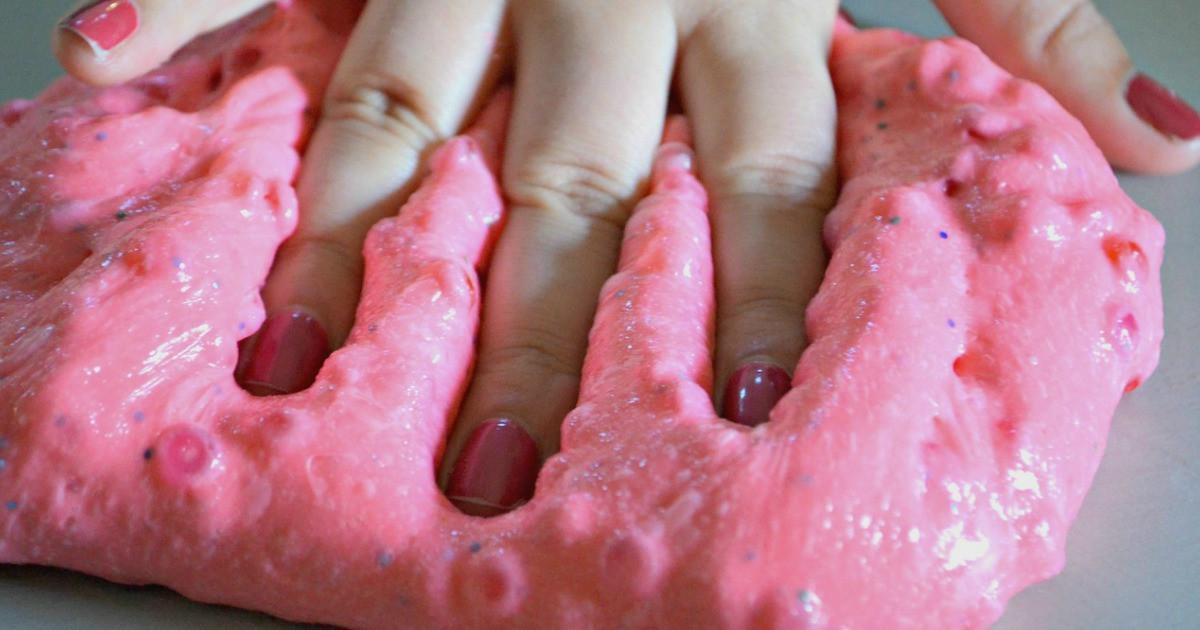  a hand pressing into crunchy slime