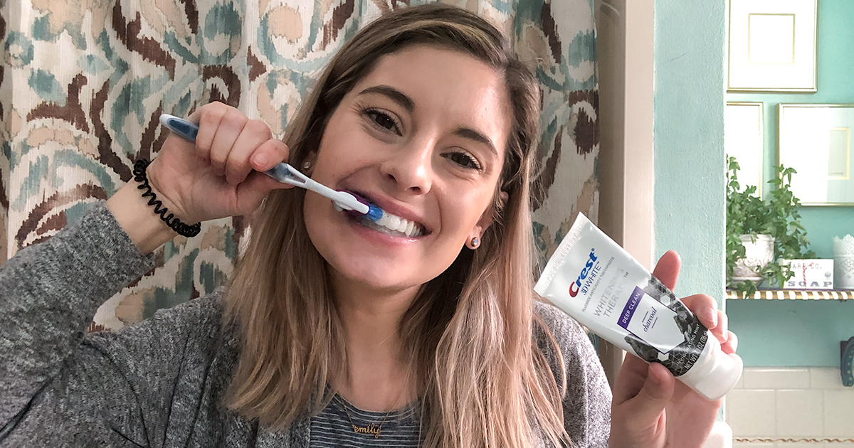 brushing teeth with crest whitening therapy toothpaste