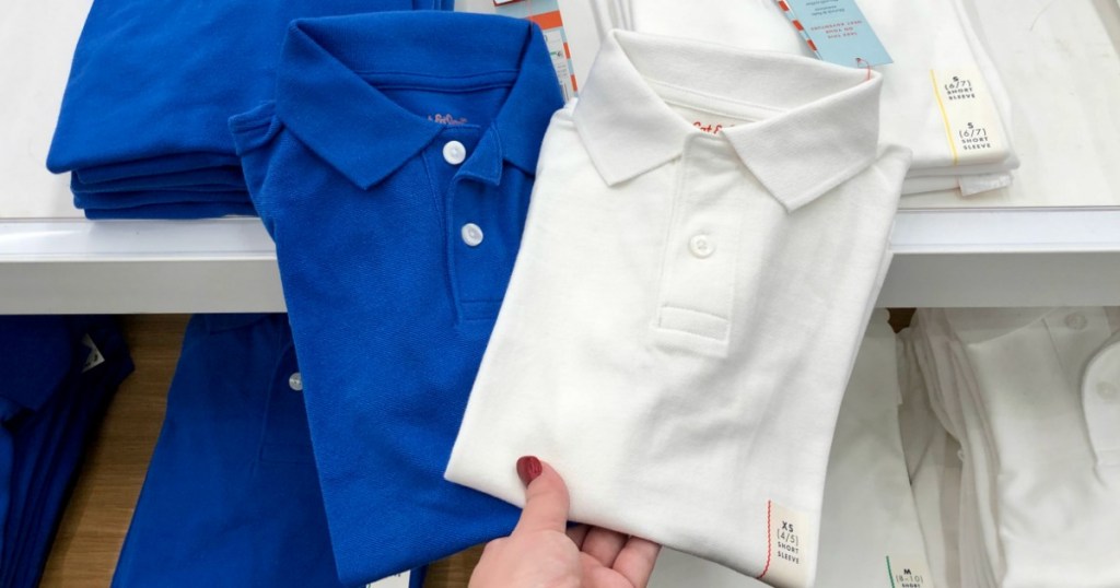 hand holding two polo shirts