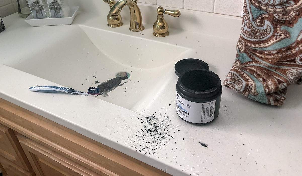 mixing together powdered charcoal and toothpaste