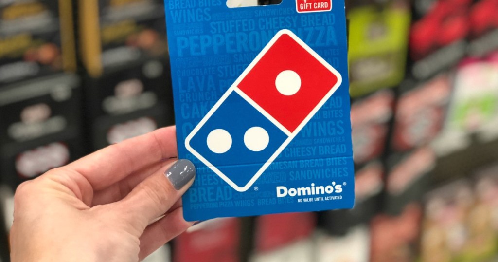 Dominos gift card being held in front of other gift cards