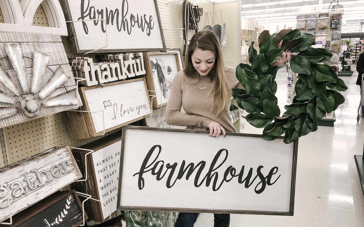 Sara holding a farmhouse sign