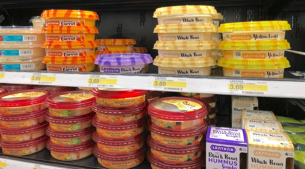 different flavors of hummus stacked on store refrigerator shelf