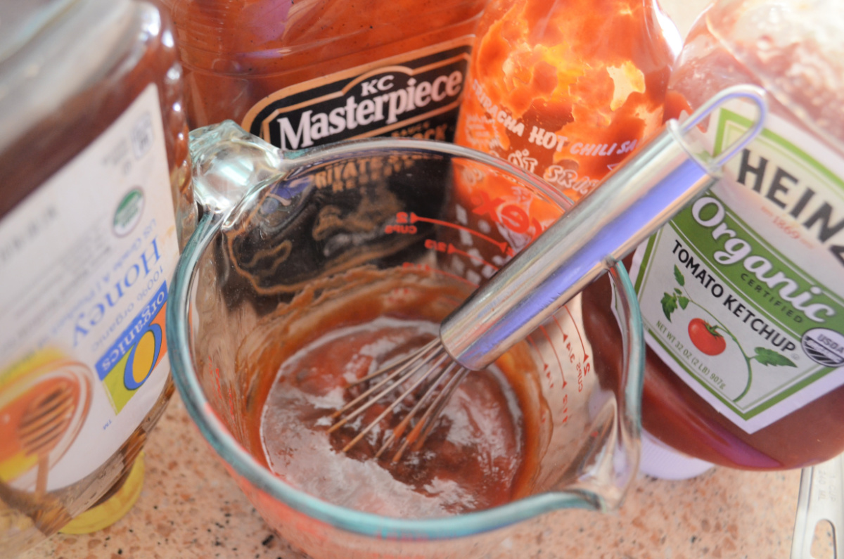 whisk in measuring cup mixing honey bbq sauce for baked wings recipe