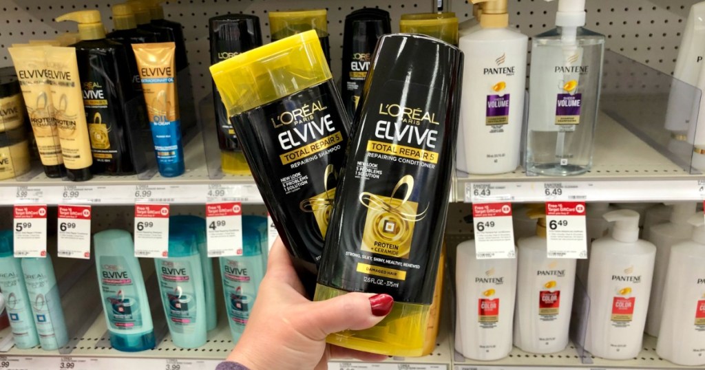 hand holding two black bottles of shampoo 
