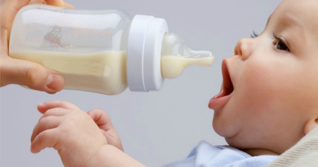 giving a baby a bottle of formula