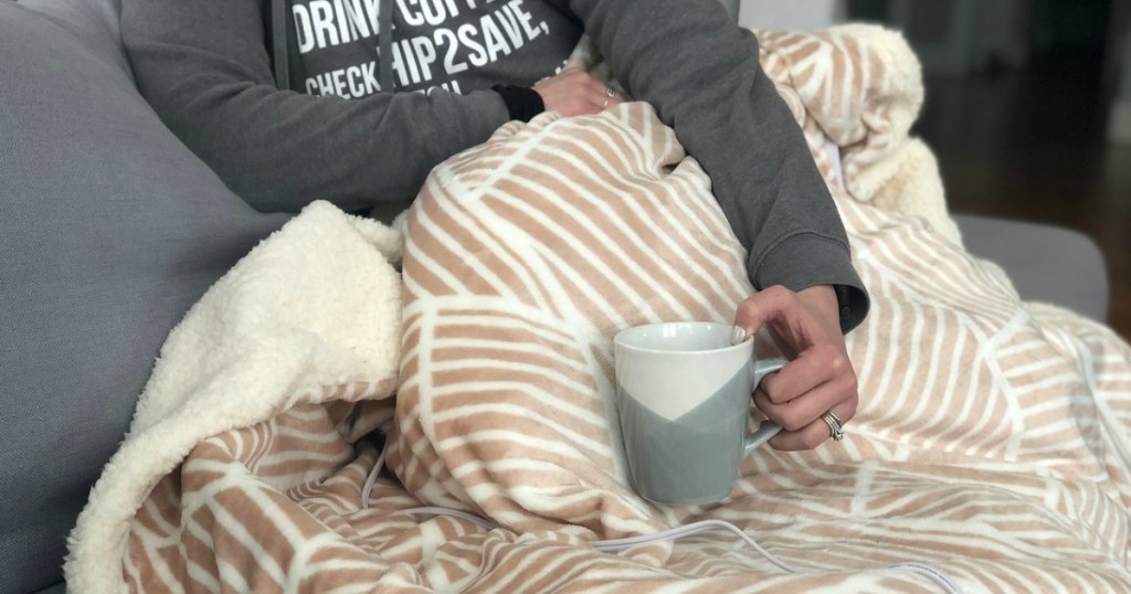 woman holding coffee mug wrapped in blanket