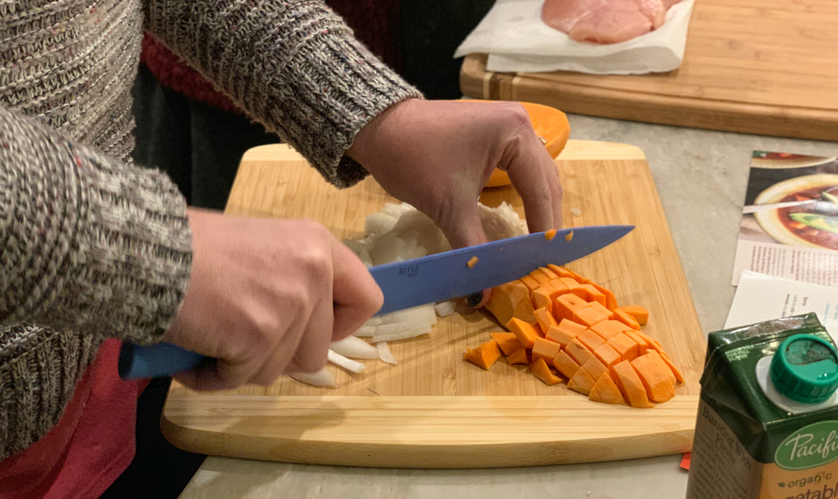 cutting sweet potatoes on a cutting board