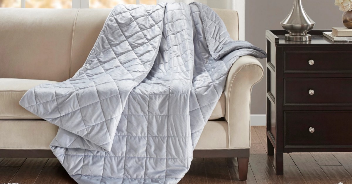 gray weighted blanket draped over couch in living room