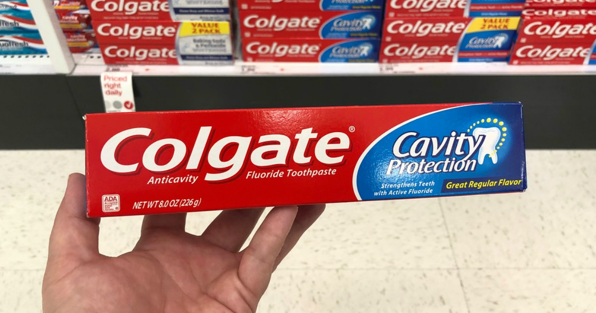 hand holding colgate cavity protection