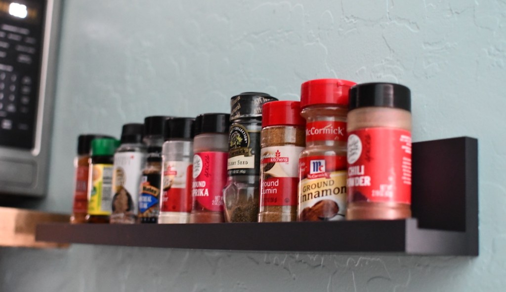 black ledge shelf with various spices on top how to hang pictures without nails