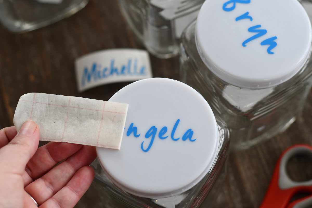 applying adhesive name decals for kindness jars 