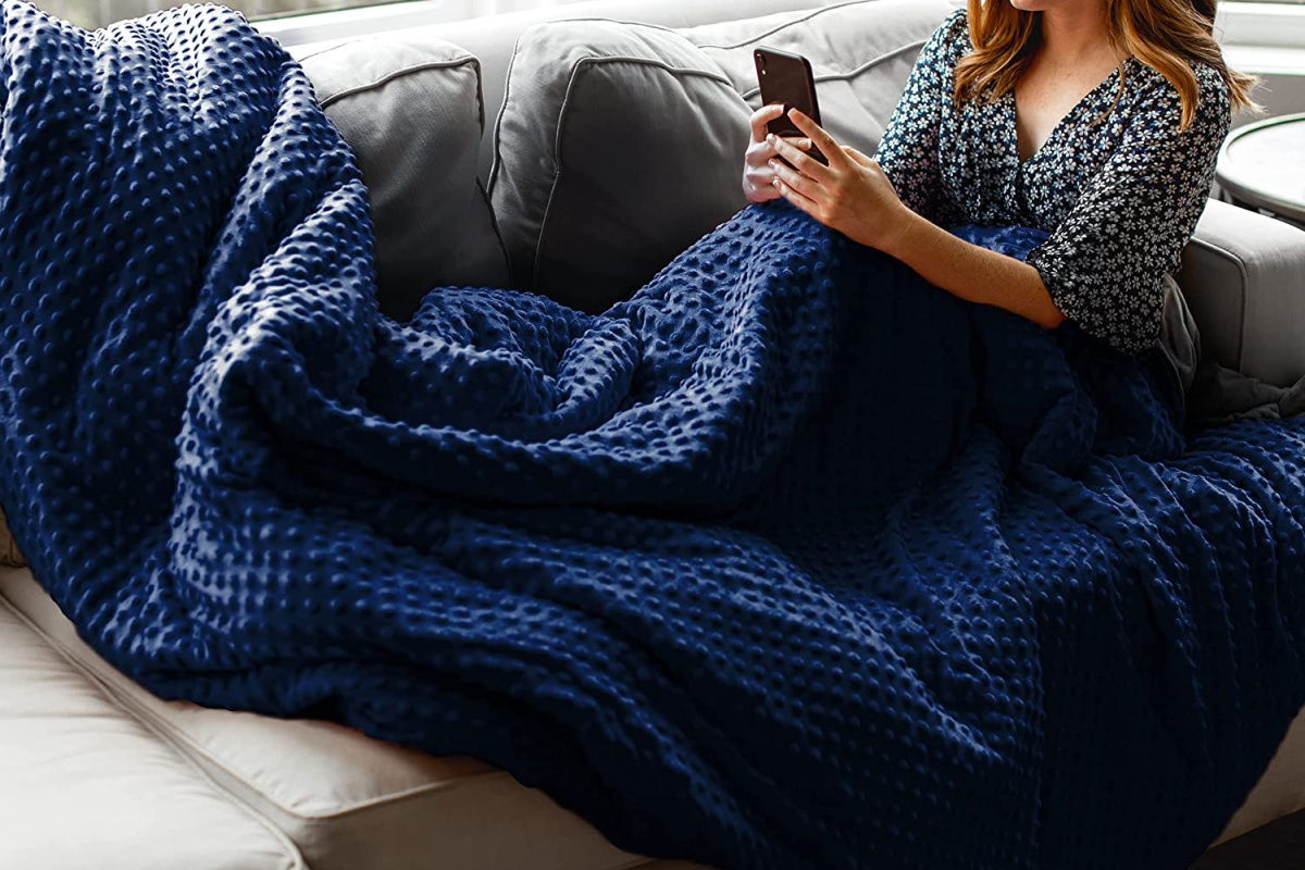 woman wearing quility blanket on couch