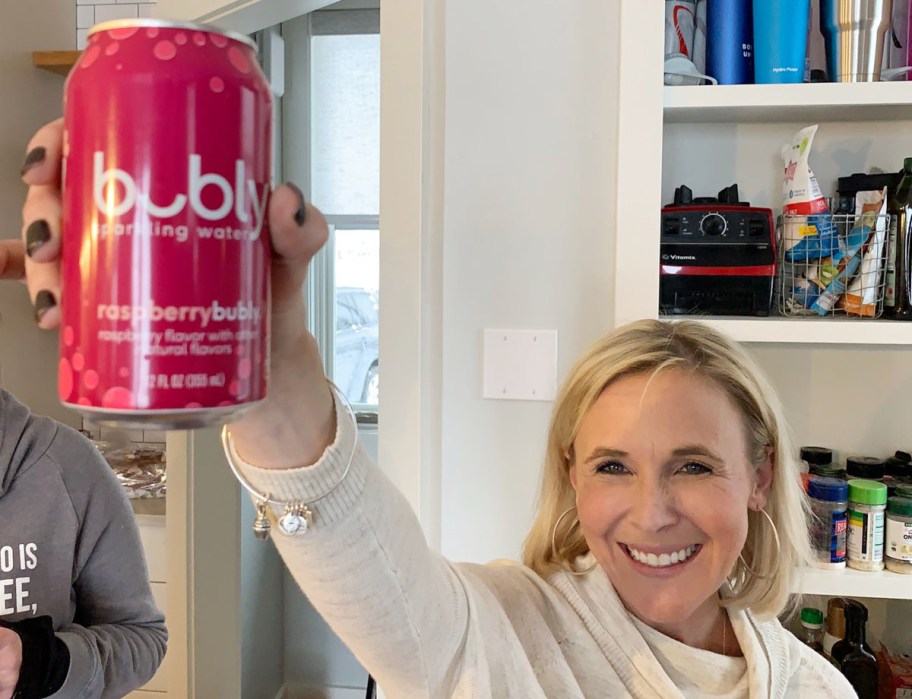 Woman holding up a can of raspberry bubly sparkling water
