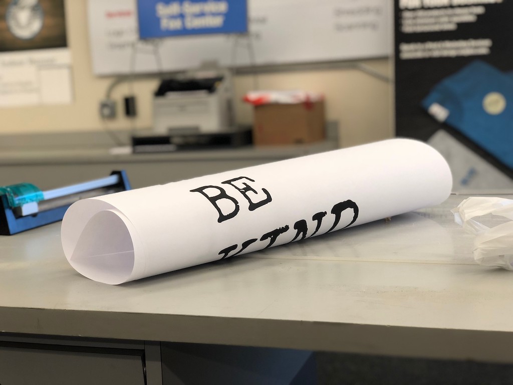 rolled up printed white sign on counter