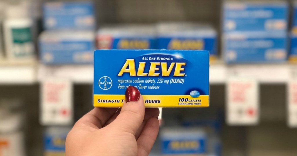 woman holding up a box of Aleve caplets
