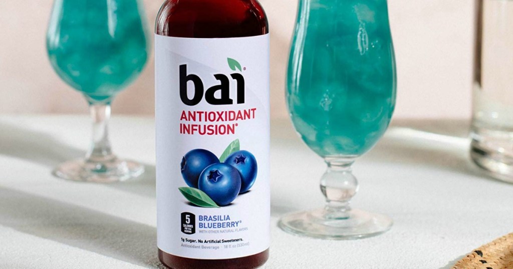 bottle of bai antioxidant infusion flavored water on a table with glasses filled with bai