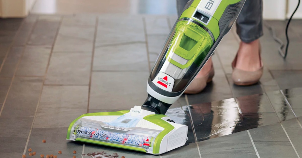 person vacuuming and mopping floor with Bissel