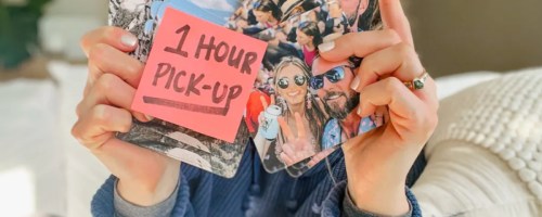 Hands holding photo coasters with one hour pick up sign