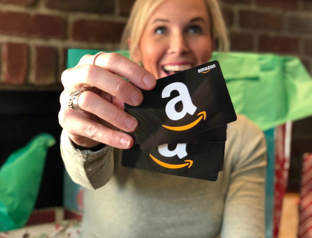 smiling woman holding Amazon gift cards