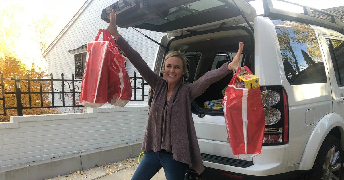 woman holding up Target bags at the back of her SUV