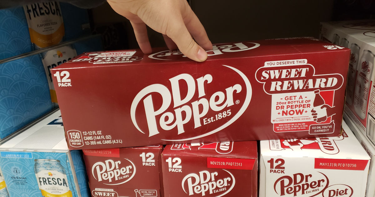 hand touching the top of a pack of dr pepper canned sodas on a store display