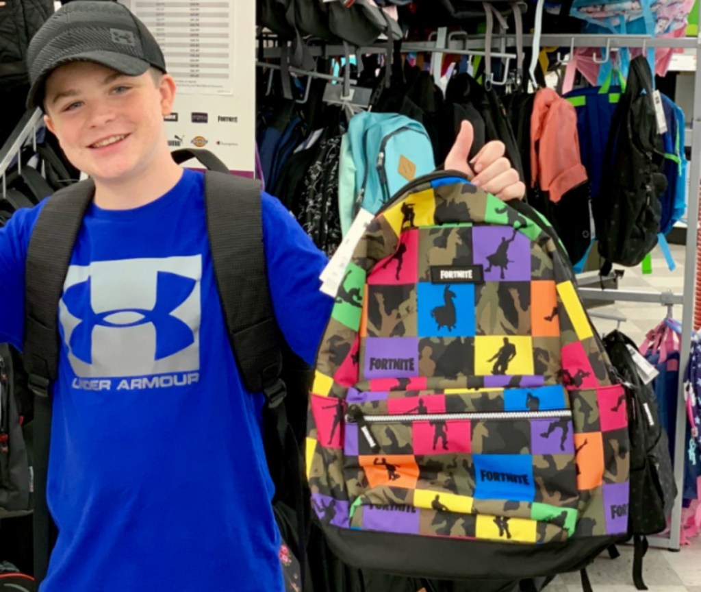 boy holding a fortnite backpack in-store