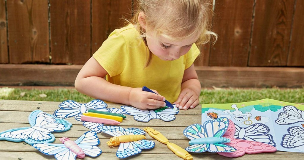 Girl coloring in Green Toys Butterfly toys