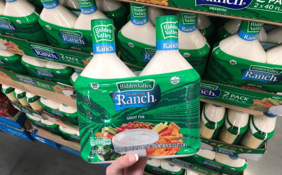hand holding a 2 pack of large bottles of Hidden Valley ranch