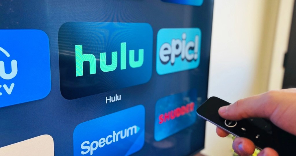 person pointing at Hulu on a TV